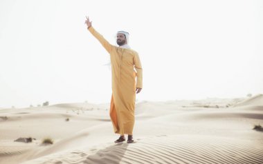 Geleneksel BAE giyen adam vakit çölde giysiler.