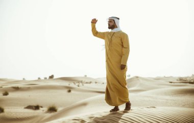 Geleneksel BAE giyen adam vakit çölde giysiler.