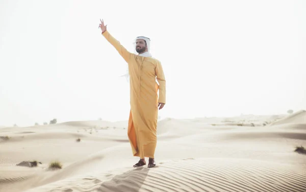 Homem vestindo roupas tradicionais uae passar o tempo no deserto — Fotografia de Stock