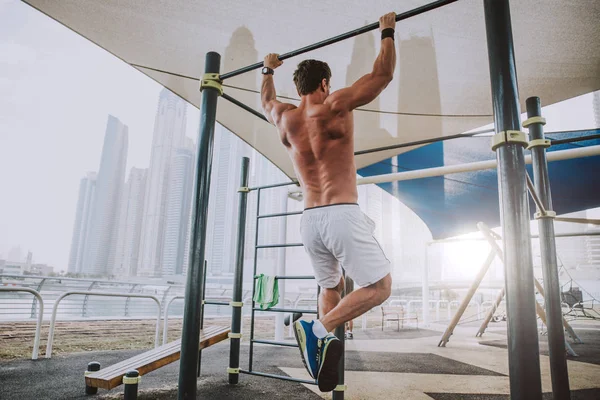 Hermoso hombre haciendo ejercicio y diferentes ejercicios al aire libre —  Fotos de Stock