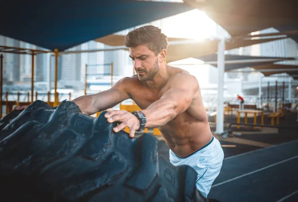 Homem bonito fazendo exercício e exercícios diferentes ao ar livre — Fotografia de Stock