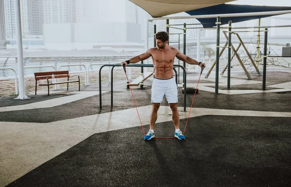 Homem bonito fazendo exercício e exercícios diferentes ao ar livre — Fotografia de Stock