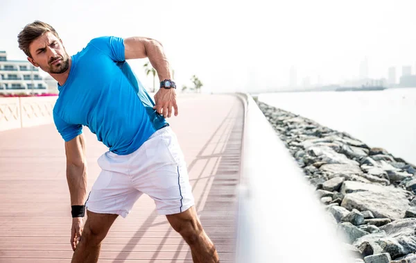 Homem bonito fazendo exercício e exercícios diferentes ao ar livre — Fotografia de Stock