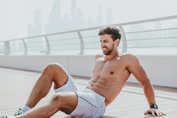 Homem bonito fazendo exercício e exercícios diferentes ao ar livre — Fotografia de Stock