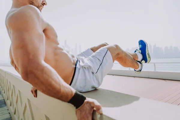 Homem bonito fazendo exercício e exercícios diferentes ao ar livre — Fotografia de Stock