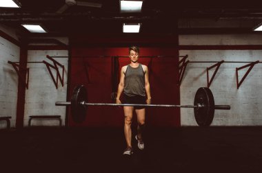 Güzel genç bir kadın spor salonunda antrenman yapıyor.