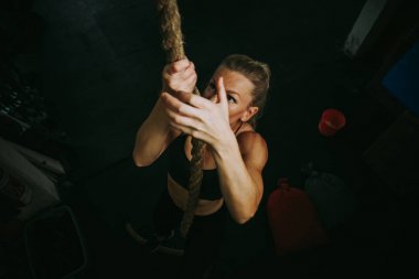 Güzel genç bir kadın spor salonunda antrenman yapıyor.