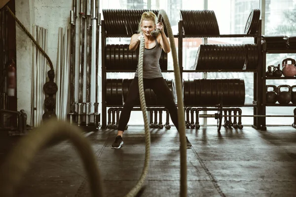 Güzel genç bir kadın spor salonunda antrenman yapıyor. — Stok fotoğraf