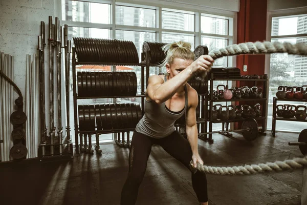 Güzel genç bir kadın spor salonunda antrenman yapıyor. — Stok fotoğraf