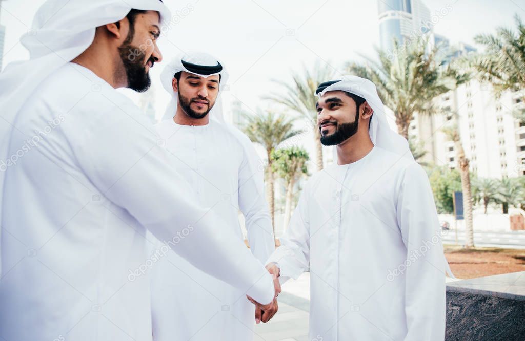 Group of businessmen talking on the street in Dubai