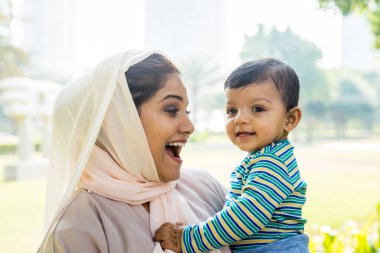 Arap anne ve küçük bebeği dışarıda oynuyorlar.