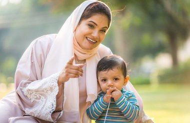 Arap anne ve küçük bebeği dışarıda oynuyorlar.