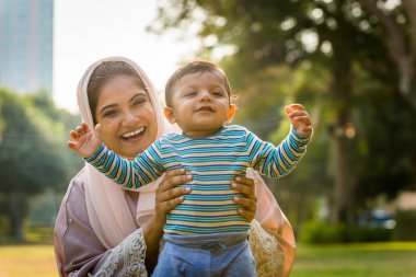 Arap anne ve küçük bebeği dışarıda oynuyorlar.