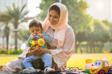 Arap anne ve küçük bebeği dışarıda oynuyorlar.