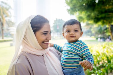 Arap anne ve küçük bebeği dışarıda oynuyorlar.
