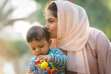 Arap anne ve küçük bebeği dışarıda oynuyorlar.