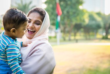 Arap anne ve küçük bebeği dışarıda oynuyorlar.