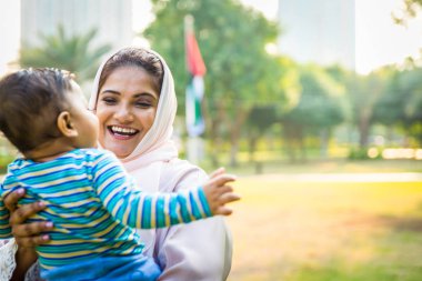 Arap anne ve küçük bebeği dışarıda oynuyorlar.