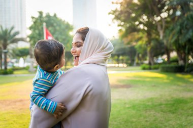 Arap anne ve küçük bebeği dışarıda oynuyorlar.