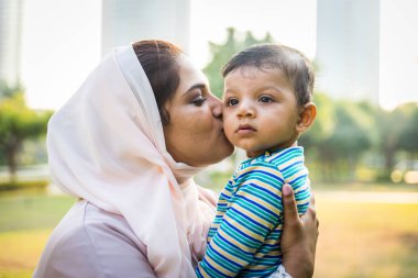 Arap anne ve küçük bebeği dışarıda oynuyorlar.