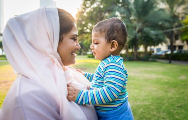 Arap anne ve küçük bebeği dışarıda oynuyorlar.