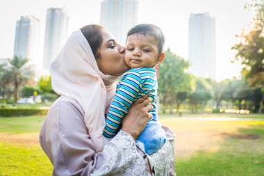 Arap anne ve küçük bebeği dışarıda oynuyorlar.