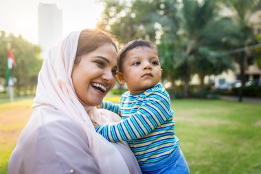 Arap anne ve küçük bebeği dışarıda oynuyorlar.