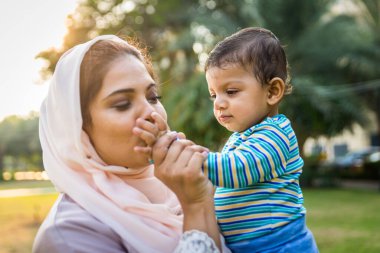 Arap anne ve küçük bebeği dışarıda oynuyorlar.