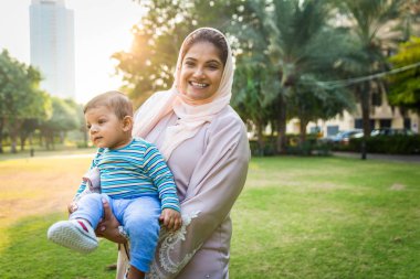 Arap anne ve küçük bebeği dışarıda oynuyorlar.