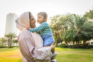 Arap anne ve küçük bebeği dışarıda oynuyorlar.