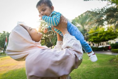 Arap anne ve küçük bebeği dışarıda oynuyorlar.