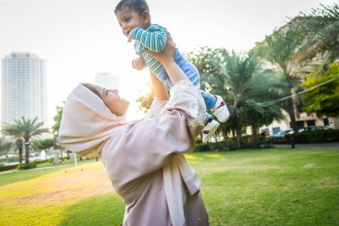 Arap anne ve küçük bebeği dışarıda oynuyorlar.