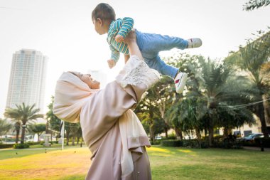 Arap anne ve küçük bebeği dışarıda oynuyorlar.