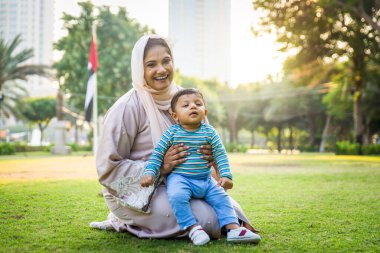 Arap anne ve küçük bebeği dışarıda oynuyorlar.