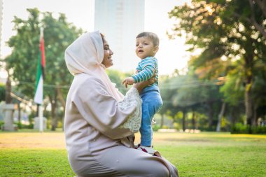 Arap anne ve küçük bebeği dışarıda oynuyorlar.