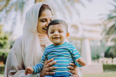 Arap anne ve küçük bebeği dışarıda oynuyorlar.