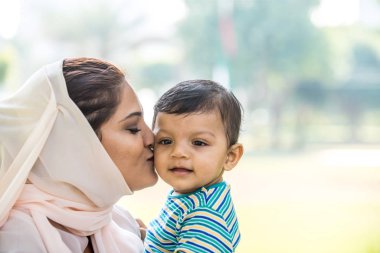 Arap anne ve küçük bebeği dışarıda oynuyorlar.