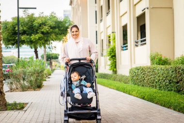 Arap anne ve küçük bebeği dışarıda oynuyorlar.