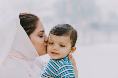 Arap anne ve küçük bebeği dışarıda oynuyorlar.