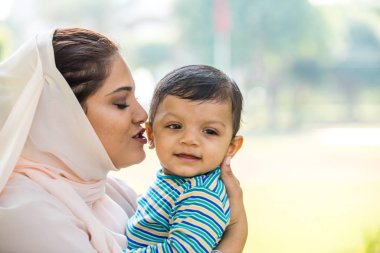 Arap anne ve küçük bebeği dışarıda oynuyorlar.