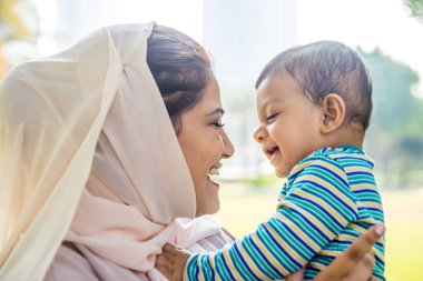 Arap anne ve küçük bebeği dışarıda oynuyorlar.