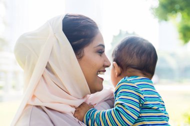 Arap anne ve küçük bebeği dışarıda oynuyorlar.