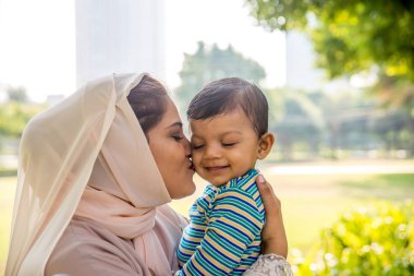 Arap anne ve küçük bebeği dışarıda oynuyorlar.