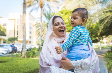 Arap anne ve küçük bebeği dışarıda oynuyorlar.