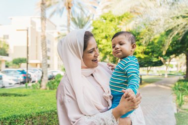 Arap anne ve küçük bebeği dışarıda oynuyorlar.