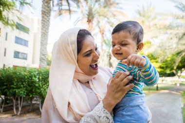 Arap anne ve küçük bebeği dışarıda oynuyorlar.