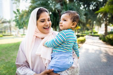 Arap anne ve küçük bebeği dışarıda oynuyorlar.