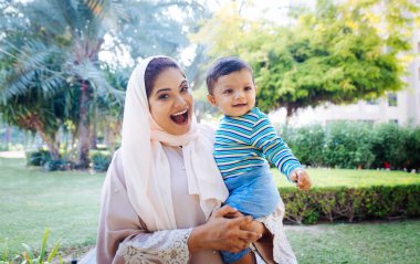 Arap anne ve küçük bebeği dışarıda oynuyorlar.