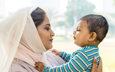 Arap anne ve küçük bebeği dışarıda oynuyorlar.