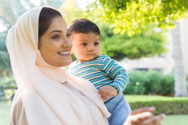 Arap anne ve küçük bebeği dışarıda oynuyorlar.